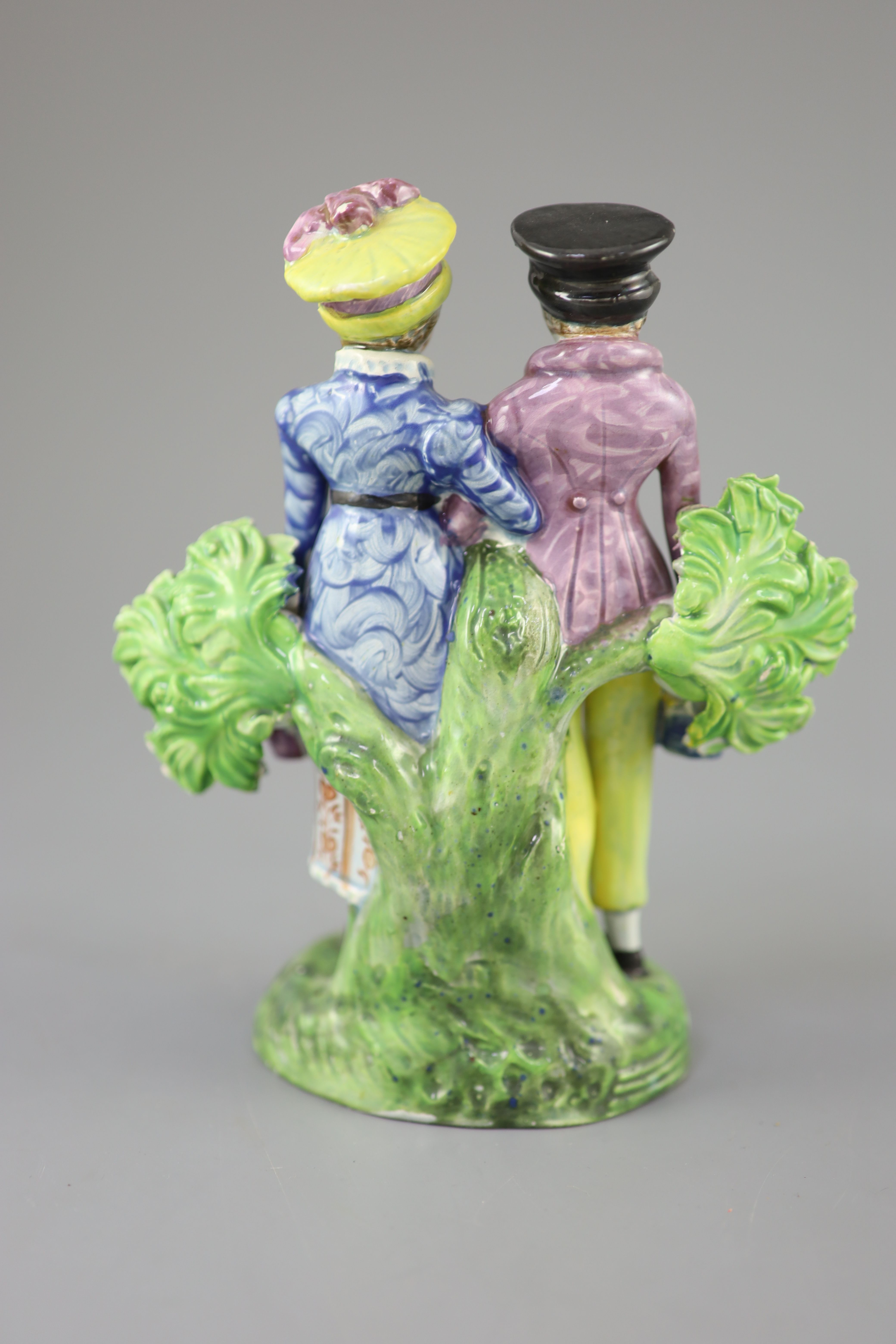 A Staffordshire pearlware group of a Dandy and Dandizette with seated dog, c.1820-30, 18cm high